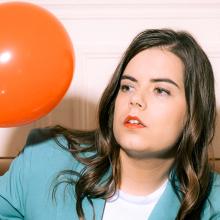 Fanny Ruwet sur un canapé regardant un ballon de baudruche