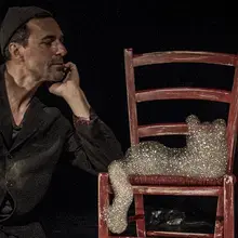 Le circassien est accoudé sur une chaise sur laquelle se trouve des bulles de savon.