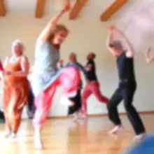Atelier de danse libre : plusieurs personnes dansent et explorent leurs mouvements dans une salle dédiée au mouvement.