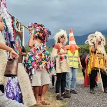 Un groupe d'adultes et d'enfants avec costumes de laine et sonnailles effectuent une transhumance artistique en Vallée d'Aspe.