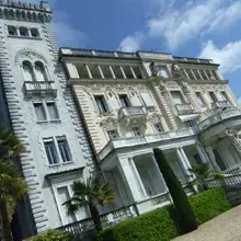 Façace typique d'un palazzo italien avec incrustations en marbre, tour médiévale et statues de Cariatides