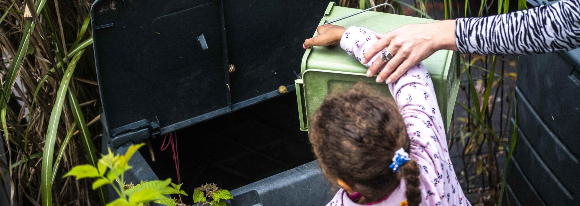Une enfant en train de composter
