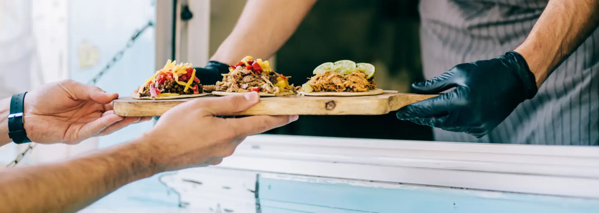 Propriétaire d'un foodtruck servant des tacos à un client