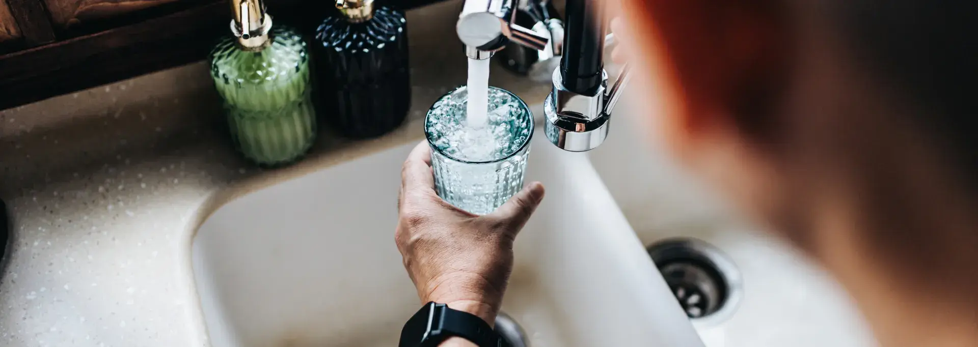 Une personne en train de se servir un verre d'eau