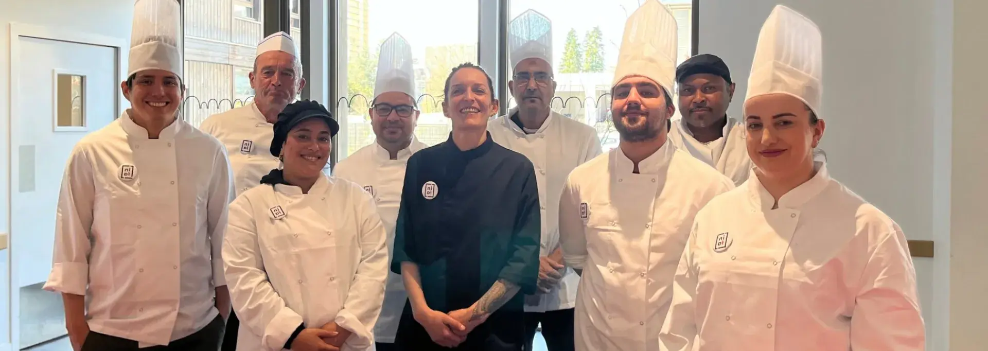 Une équipe de cuisiniers posent dans une cuisine 