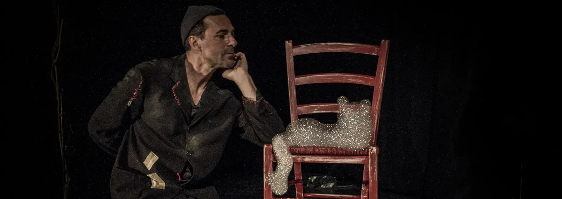 Le circassien est accoudé sur une chaise sur laquelle se trouve des bulles de savon.