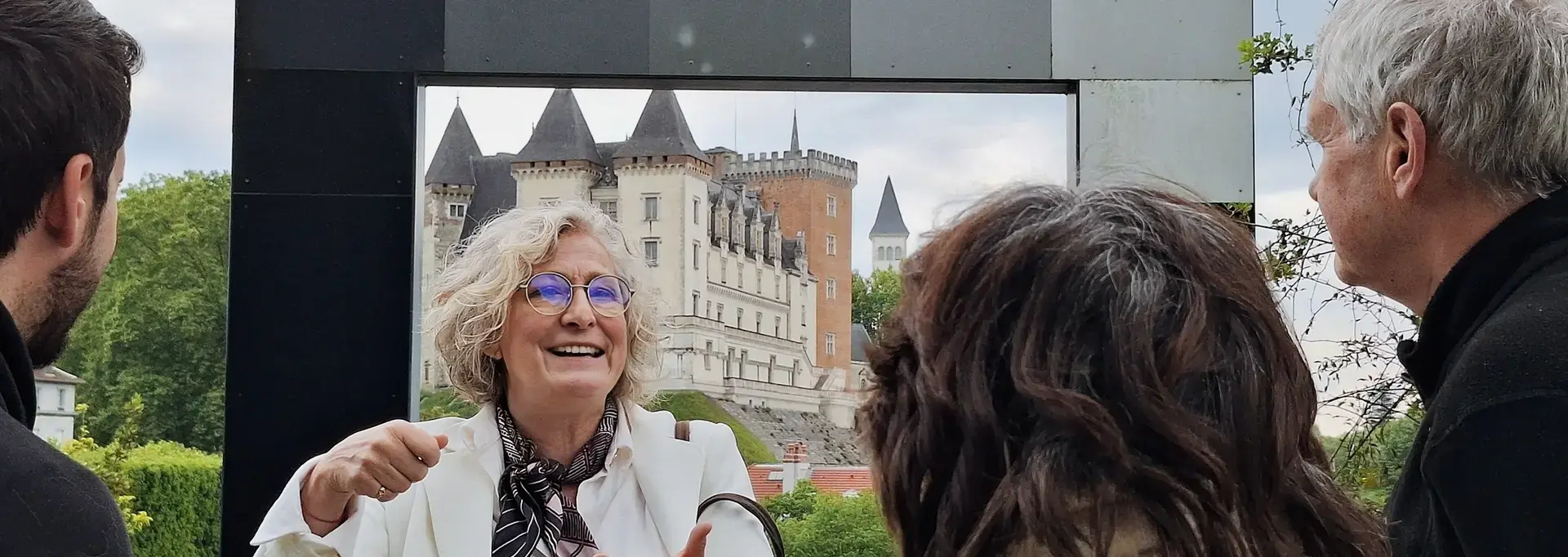 La guide, Caroline Barrow, est en train de parler avec des visiteurs devant le belvédère qui donne sur le château