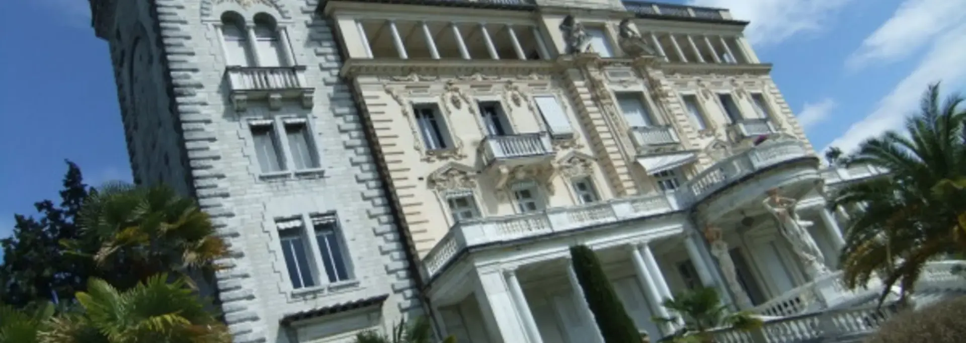 Façace typique d'un palazzo italien avec incrustations en marbre, tour médiévale et statues de Cariatides