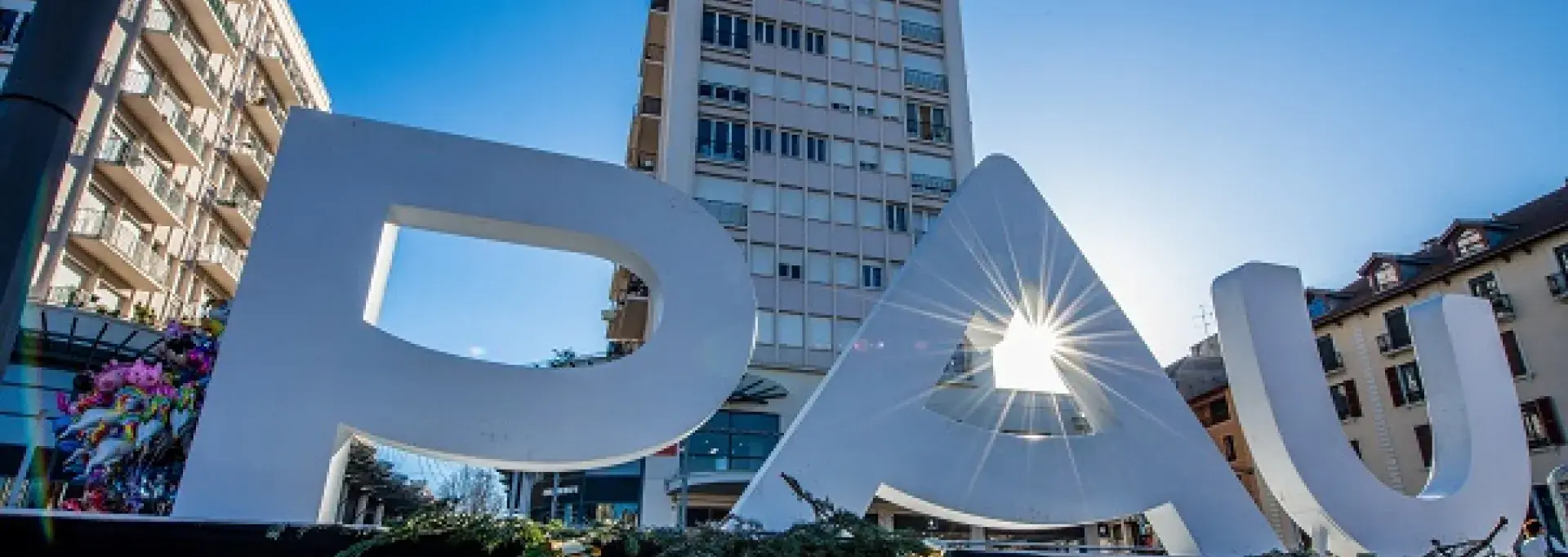 Le nom de PAU est affiché en grandes lettres devant lesquelles les visiteurs aiment se photographie.