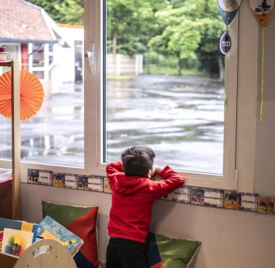 Un enfant tout seul à une fenetre