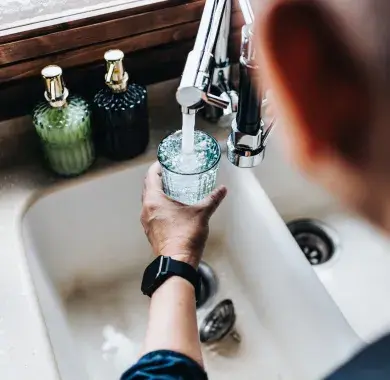 Une personne en train de se servir un verre d'eau