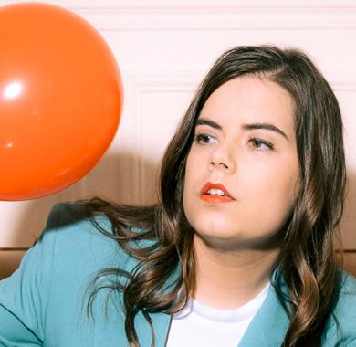 Fanny Ruwet sur un canapé regardant un ballon de baudruche