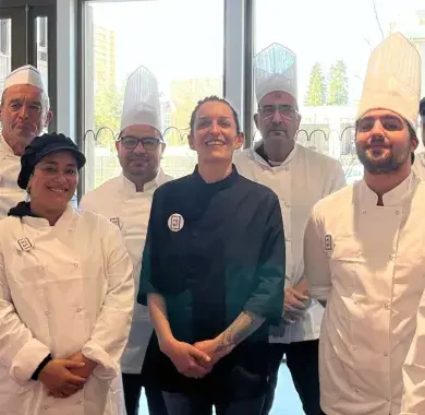 Une équipe de cuisiniers posent dans une cuisine 