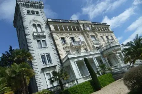 Façace typique d'un palazzo italien avec incrustations en marbre, tour médiévale et statues de Cariatides