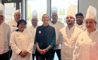 Une équipe de cuisiniers posent dans une cuisine 