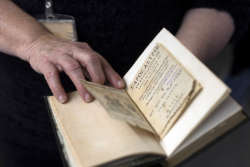 Un homme montre un livre ancien avec sa main